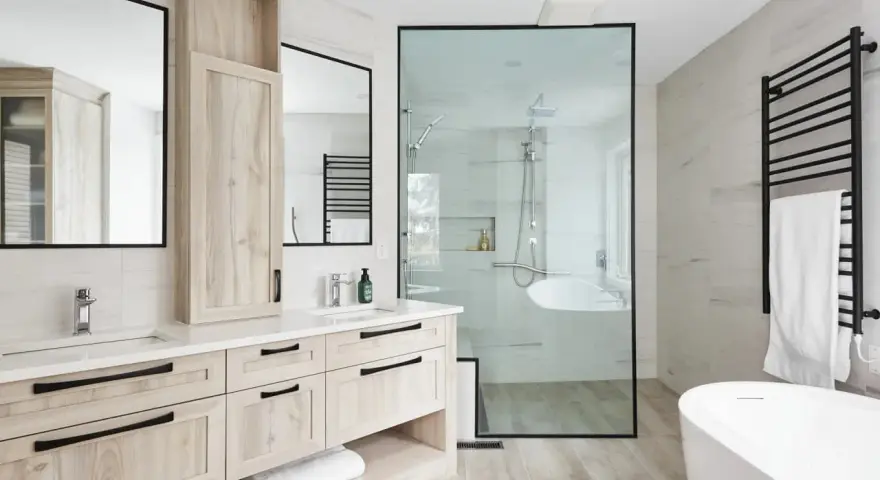 Salle de bain moderne avec double vasque en bois clair, douche vitrée et baignoire îlot. Un design épuré pour une ambiance zen.