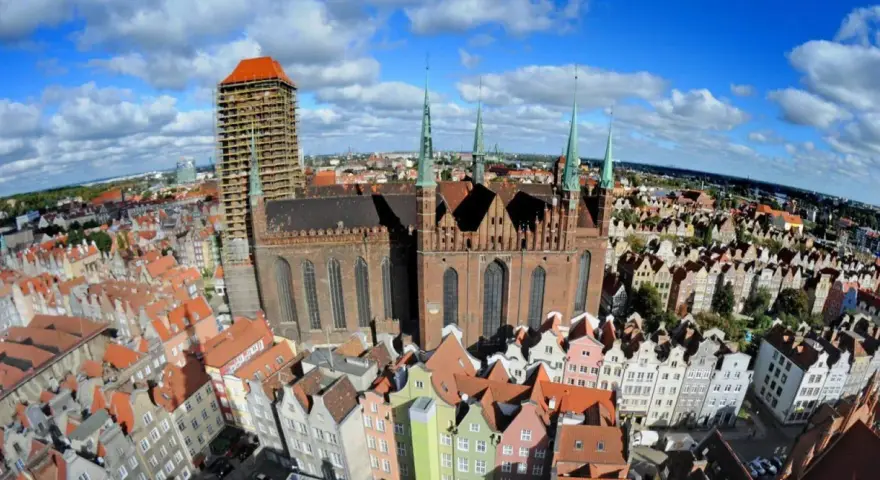 Widok z lotu ptaka na Bazylikę Mariacką w Gdańsku i kolorowe kamienice Starego Miasta.