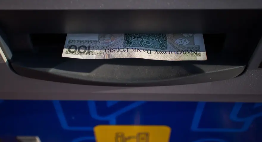 Banknot 100 zł włożony do wpłatomatu. Tak działa wpłatomat: wkładasz pieniądze, a urządzenie je przyjmuje.