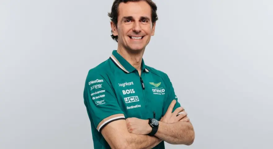 Pedro de la Rosa, con brazos cruzados, sonríe con confianza. Viste un polo verde del equipo Aston Martin Aramco.