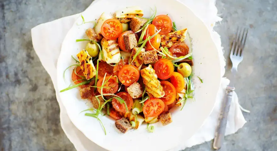 En härlig halloumi sallad med körsbärstomater, krutonger och gröna oliver.