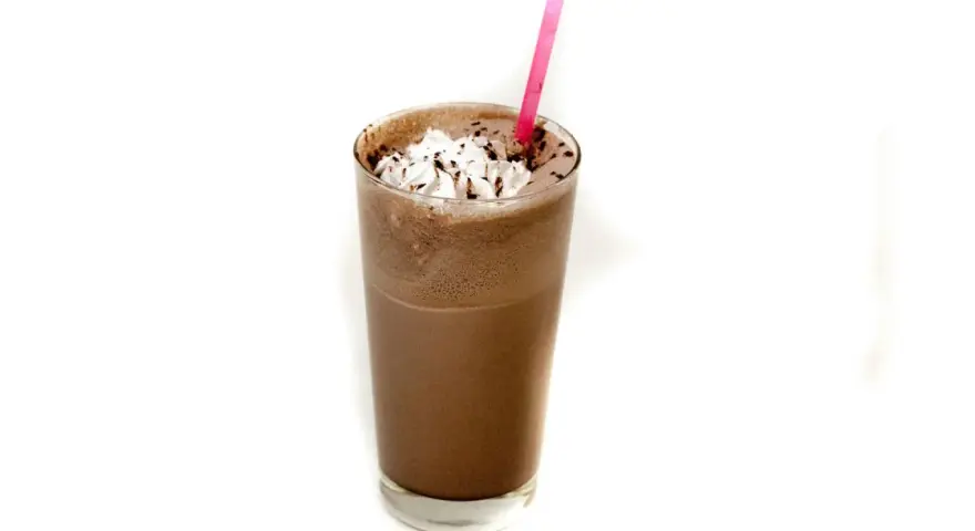 Un delizioso frappè al cioccolato con panna montata e una cannuccia rosa.