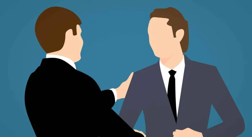 Deux hommes en costume se serrent la main, symbolisant un accord mutuel pour comment négocier une rupture conventionnelle.