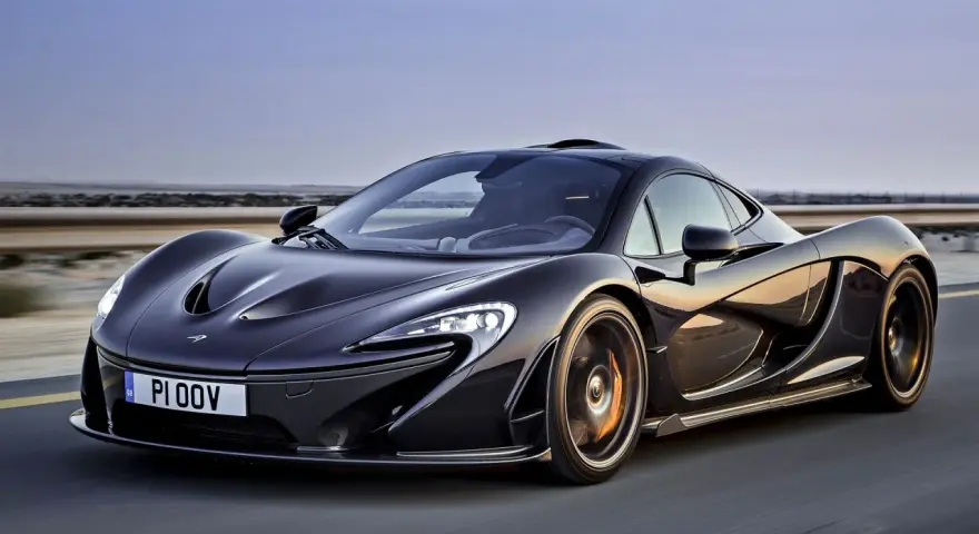 Czarny McLaren P1 w ruchu, z widocznym numerem rejestracyjnym PI 00V. Jego cena jest astronomiczna, ale wygląd zapiera dech.