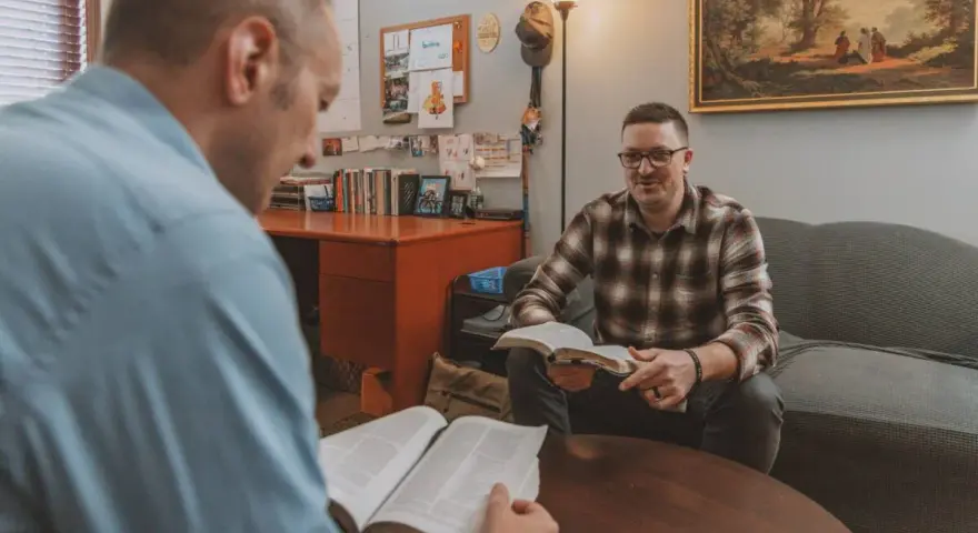 Two men discuss the Bible, exploring why God sent Jesus to save humanity.