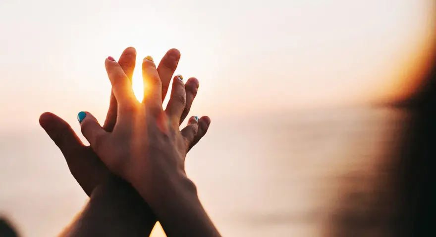 Two hands clasped at sunset, a symbol of purity and what is chastity: a deep, respectful connection.