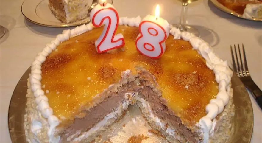 Tarta San Marcos con velas de cumpleaños número 28, lista para celebrar.