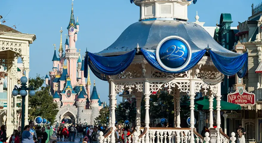 El castillo rosa de Disneyland Paris se alza majestuoso, con un quiosco decorado para celebrar el 25 aniversario.