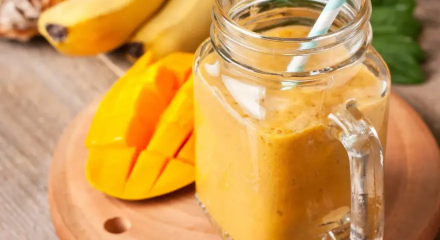 Słoneczny koktajl zamiast śniadania: gęsty, pomarańczowy napój z mango i bananów w słoiku, gotowy do wypicia.