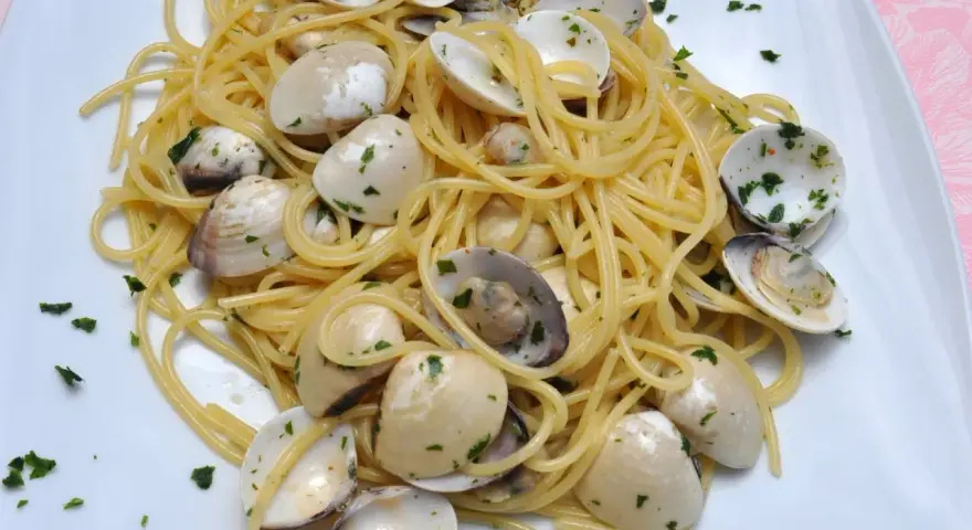 Pyszne Spaghetti con le Vongole przepis. Aromatyczny makaron z małżami i natką pietruszki, gotowy do podania.
