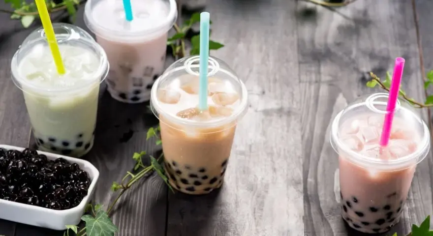 Różne rodzaje herbaty do bubble tea: zielona, mleczna, brązowa i różowa, z tapioką.