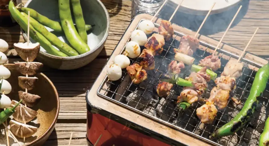 Grillowane **yakitori** z kurczakiem i warzywami, obok miska fasolki i grzybów na patyczkach.