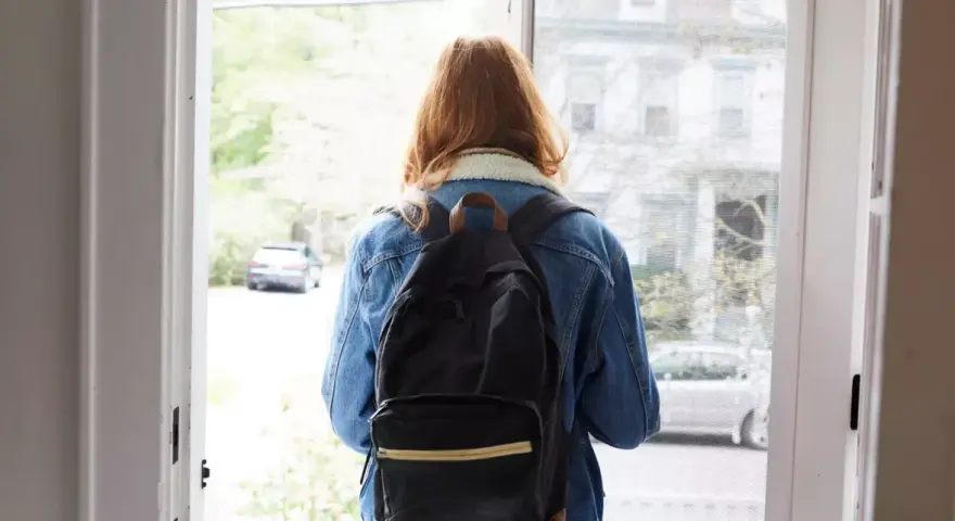 Ragazza con zaino, forse alle prese con i sintomi ADHD adulti donne, esce di casa.