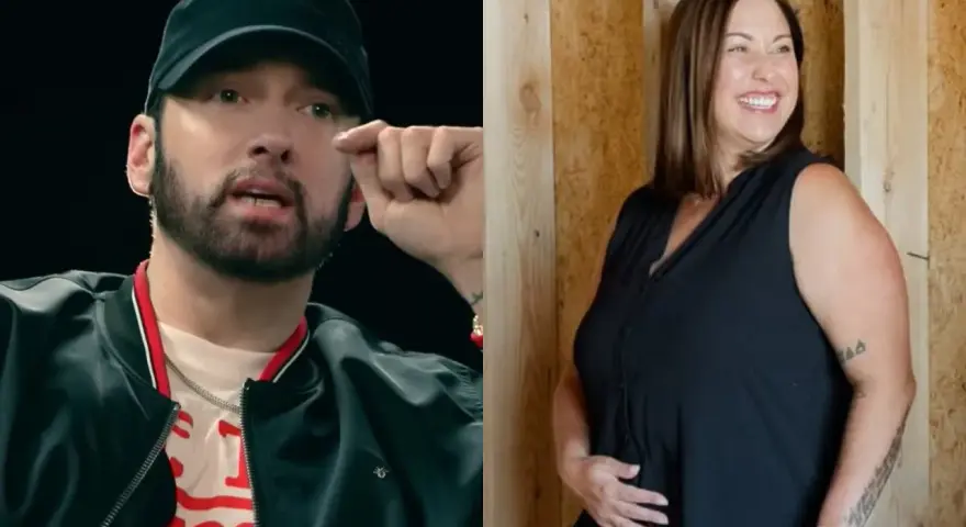 Eminem w czapce i czarnej kurtce obok uśmiechniętej kobiety w czarnej bluzce.