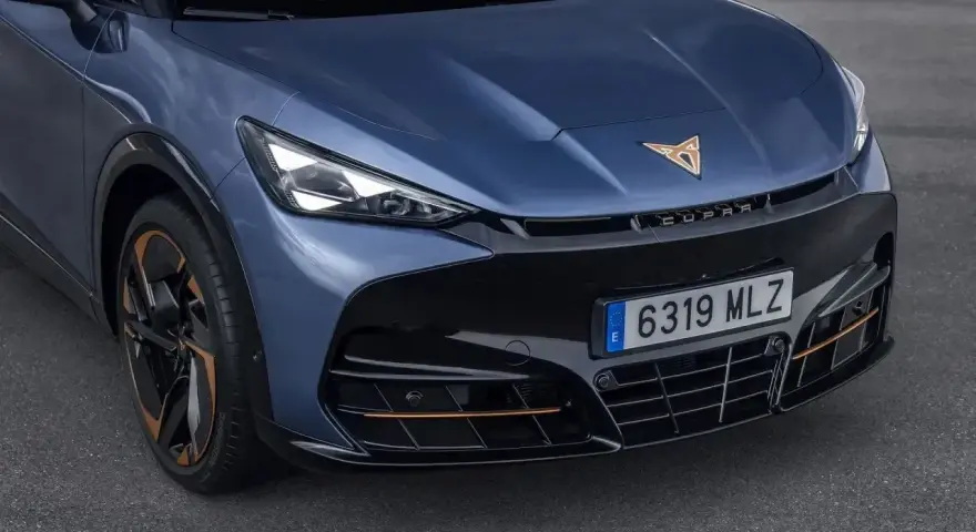 Niebieski Cupra Tavascan z miedzianymi akcentami i sportowym grillem.