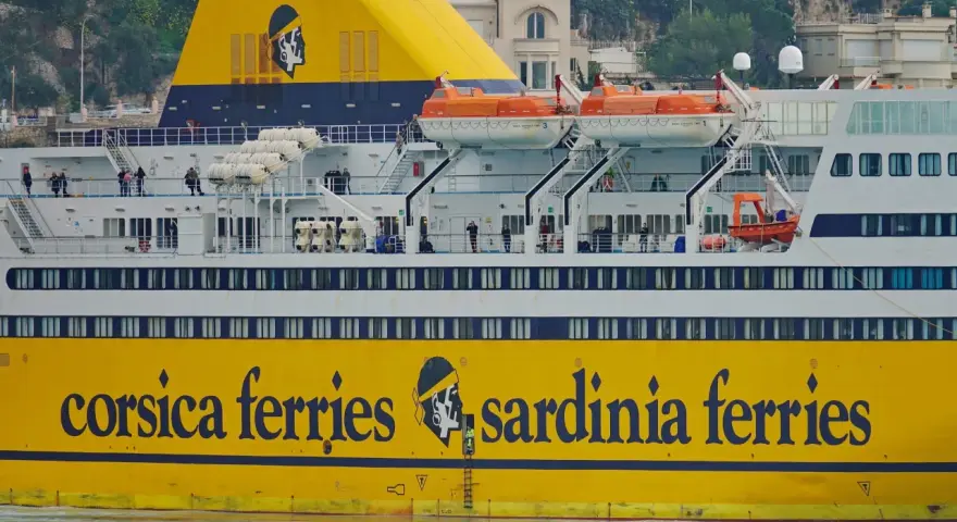 Żółty prom "Corsica Ferries Sardinia Ferries" z ludźmi na pokładzie, gotowy do podróży motocyklem na Sardynię.