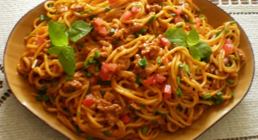 Spaghetti bolognese – prosty przepis. Aromatyczny sos mięsny z pomidorami i bazylią na złocistym makaronie.