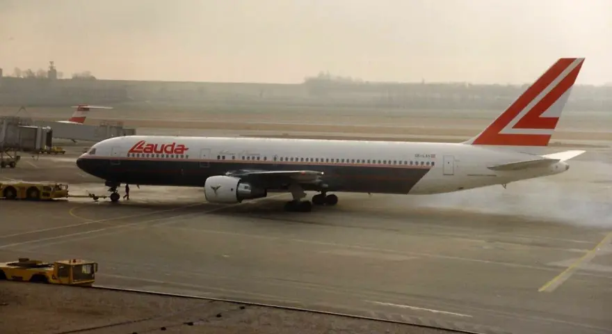 Samolot Lauda Air z charakterystycznym ogonem, kołujący po płycie lotniska.