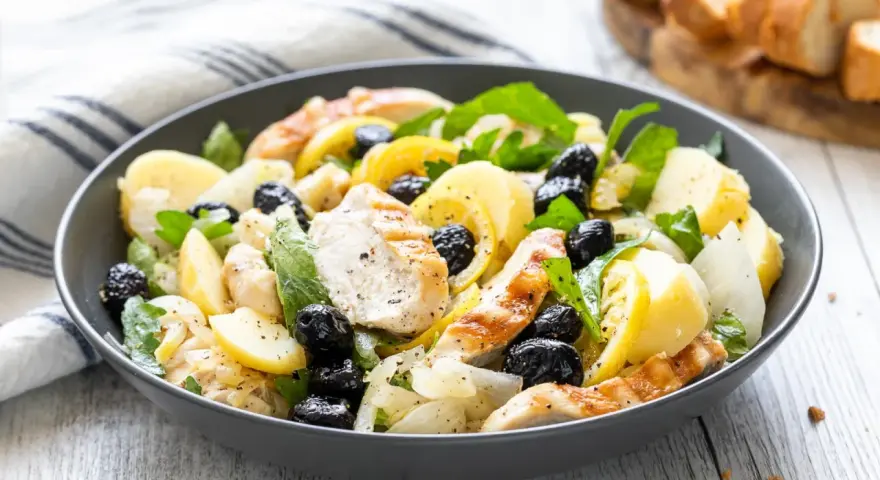 Insalata di pollo sfiziosa con patate, olive nere e limone, un piatto fresco e saporito.