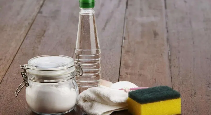 Bicarbonate de soude dans un bocal, une bouteille de vinaigre, une éponge et une brosse à dents. Idéal pour 15 utilisations du bicarbonate de soude.