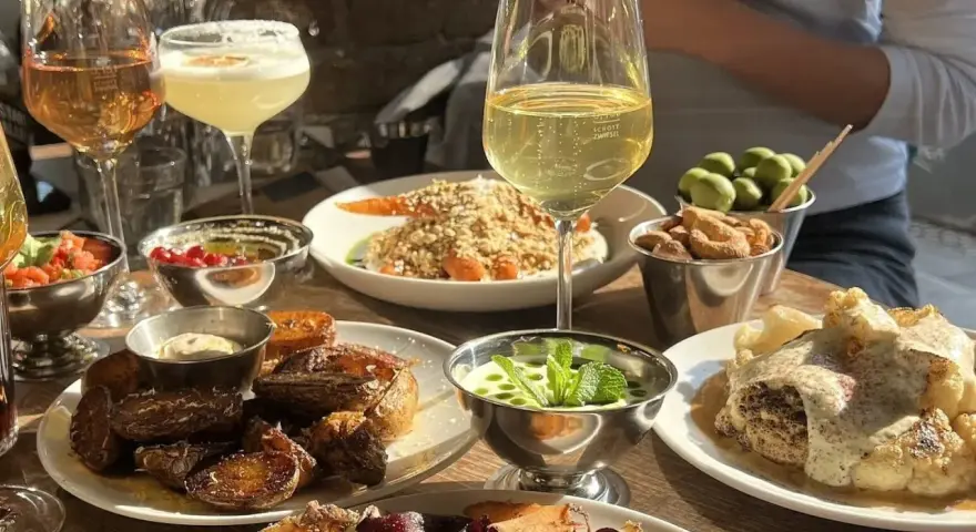 Leckeres Essen und Getränke im yamyam Berlin: geröstete Kartoffeln, Blumenkohl, Oliven und Cocktails.