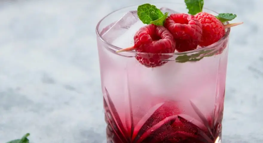 Orzeźwiający drink Wściekły Pies z malinami i miętą, idealny na letnie popołudnie.