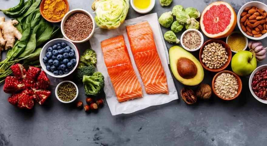 Zdrowe składniki na dietę wątrobową: łosoś, jagody, awokado, orzechy, warzywa i owoce.