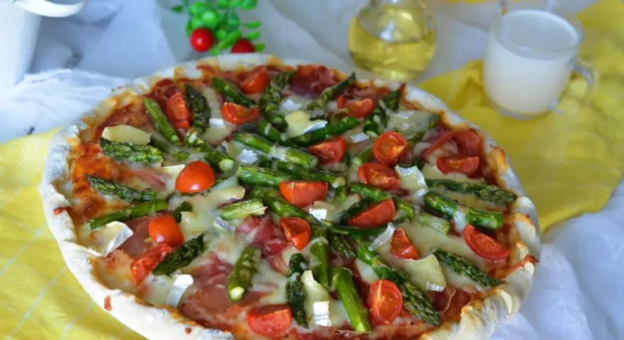 Pyszna pizza ze szparagami, pomidorkami i serem. Idealna na wiosenny obiad.