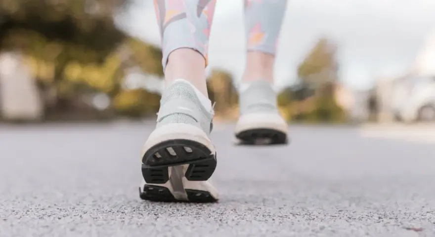 Passi leggeri su un sentiero, un invito a muoversi. Camminare è il miglior sport contro la depressione, un passo alla volta verso il benessere.