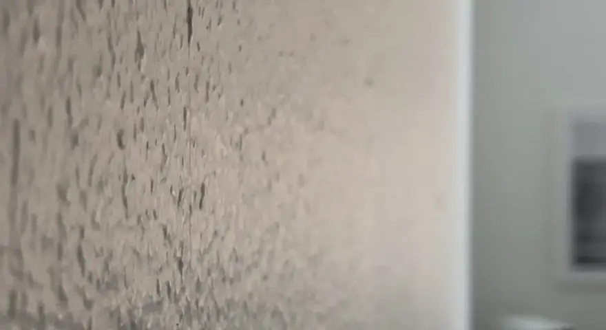 Närbild på en vägg med en grov textur, som om någon har valt att bredspackla strukturtapet för att skapa en unik yta.