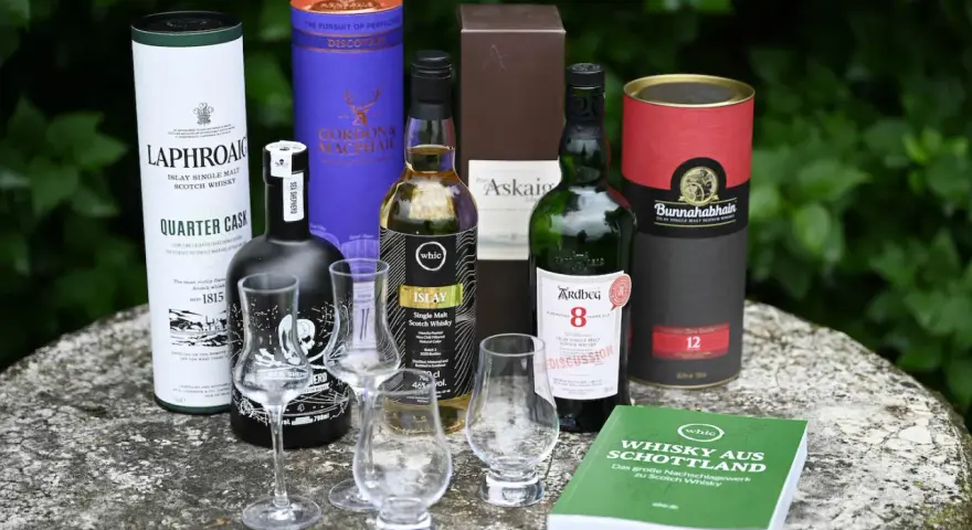 Laphroaig Aussprache: Eine Auswahl schottischer Single Malts, darunter Laphroaig Quarter Cask, Ardbeg 8, Bunnahabhain 12 und mehr, bereit für eine Verkostung.
