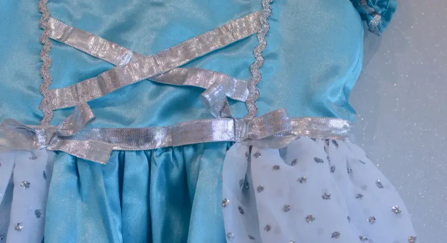Détail d'une robe de princesse bleue avec laçage argenté. Un patron robe princesse gratuit à télécharger pour créer la magie.