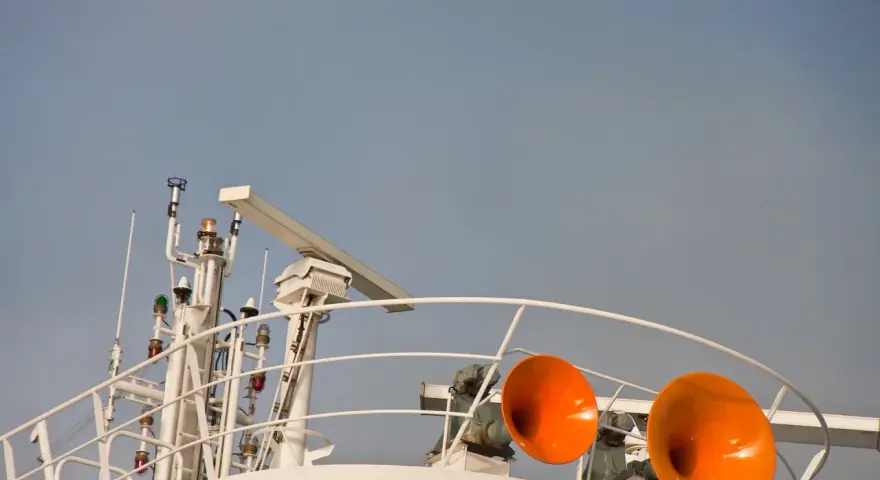 Zwei orangefarbene Schiffshörner sind bereit, ihr Signal zu geben. Das Schiff hupt 3 mal lang, um seine Anwesenheit zu signalisieren.