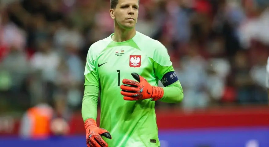 Wojciech Szczęsny, bramkarz reprezentacji Polski, w zielonej koszulce i pomarańczowych rękawicach. Jego imponujący wzrost pozwala mu skutecznie bronić.