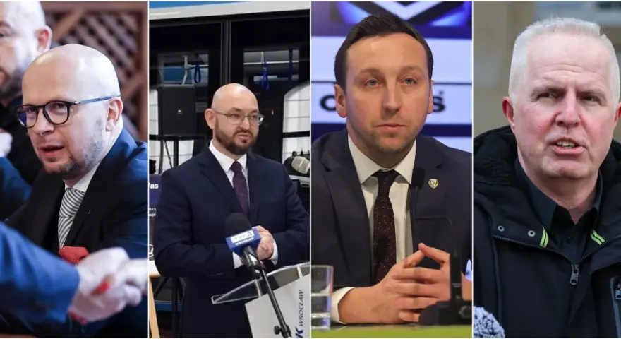 Czterech mężczyzn w garniturach i kurtce, jeden ściska dłoń.