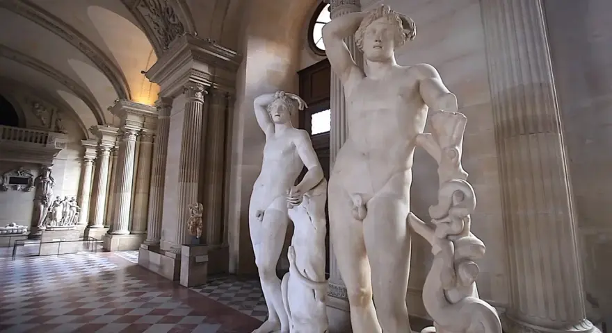 Les sculptures en marbre d'Amour et Psyché de Canova, dans un musée avec des colonnes et un sol à damier.