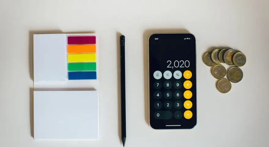 Kalkulator na telefonie pokazuje 2020, obok leżą monety euro. To może być początek oszczędzania na depozyt prosumencki.