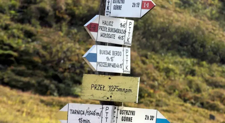 Słupki z drogowskazami w górach pokazują, co oznacza czarny szlak w górach – kierunek i czas dojścia do celu.