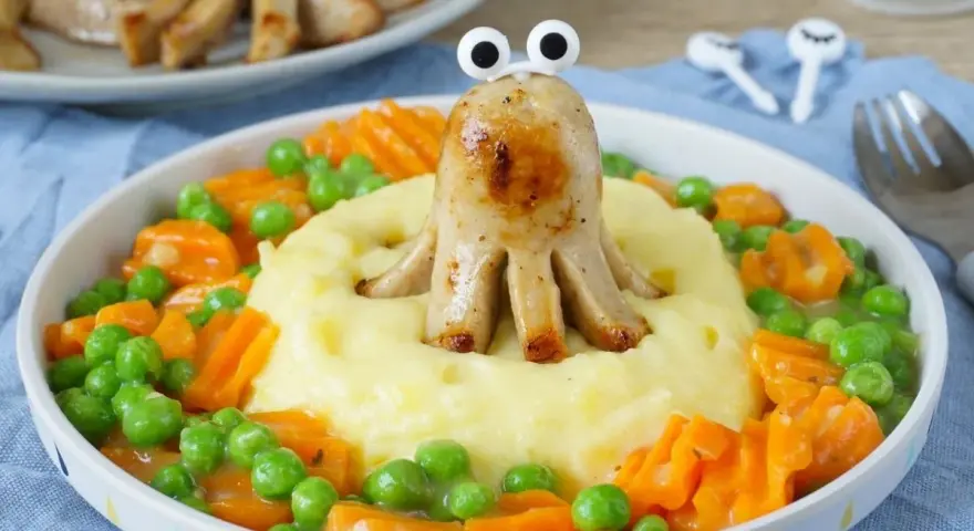 Kreatives Abendessen für Kinder: Wurst-Oktopus auf Kartoffelbrei mit Erbsen und Karotten. Ein lustiges Gericht, das Kinder lieben werden!