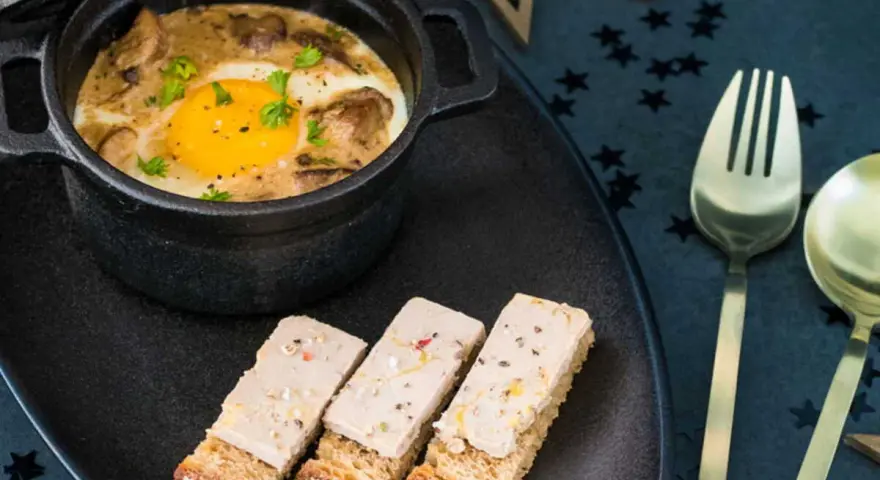 Œuf cocotte aux champignons et foie gras, servi avec des toasts. Un délice pour une recette de fête.