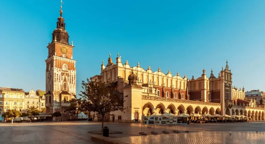 Rynek Główny w Krakowie, idealne miejsce na city break. Sukiennice i wieża Ratuszowa w słońcu.