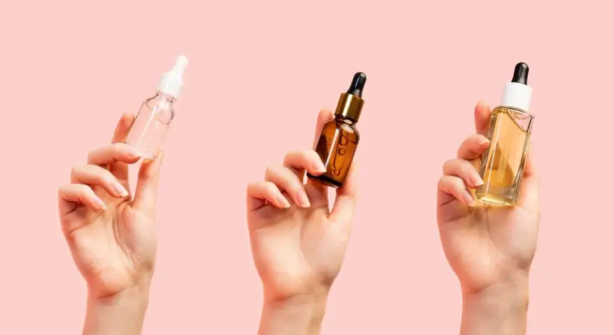 Trzy dłonie trzymają buteleczki z serum. Zastanawiasz się, jakie serum do twarzy po 40. wybrać?