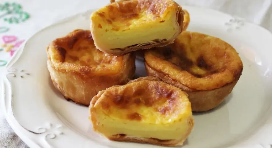 Pastel de arroz con relleno cremoso y masa hojaldrada, servido en un plato blanco.