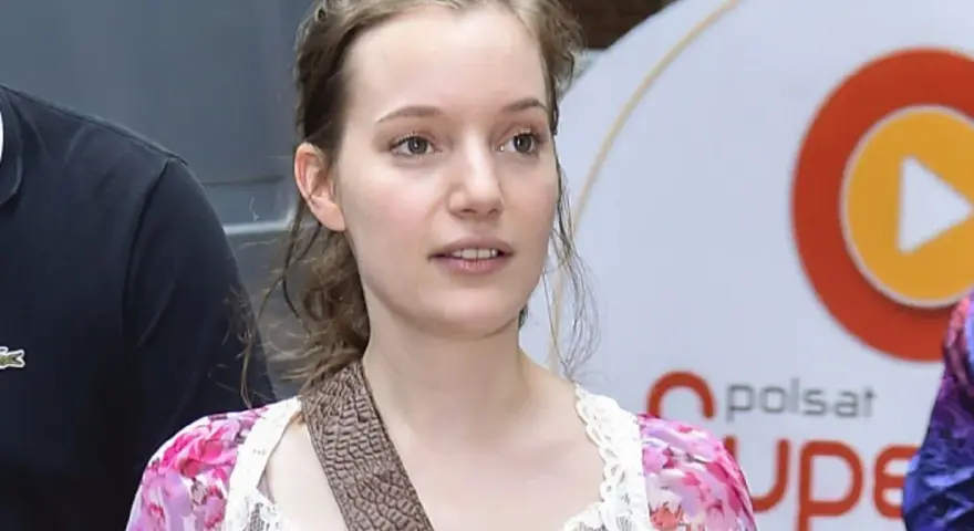 Zuzanna Jurczak, The Voice of Poland, w kwiecistej sukience z koronką, z brązowym paskiem przez ramię.