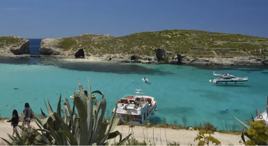 Malta wakacje: turkusowa woda, skaliste wybrzeże z jaskiniami i łodzie. Idealne miejsce na relaks.