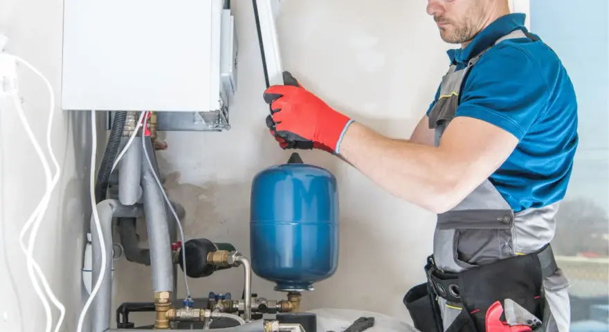 Instalator sprawdza podzespoły kotła gazowego. Zastanawiasz się, ile kosztuje piec gazowy?