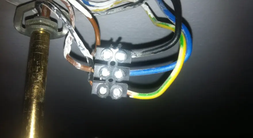 Widok z bliska na połączenie przewodów elektrycznych żyrandola z kostką.