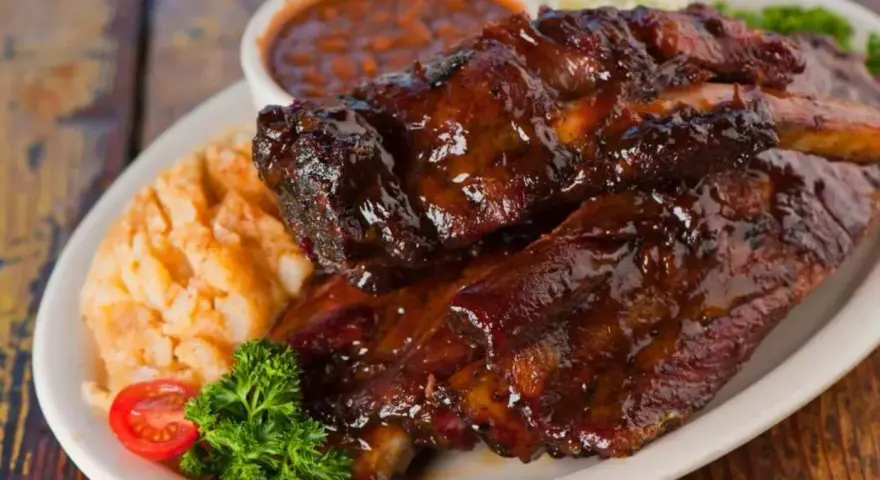 Soczyste żeberka w sosie BBQ, podane z puree ziemniaczanym i fasolką. Idealna marynata do żeberek sprawia, że mięso jest kruche i aromatyczne.