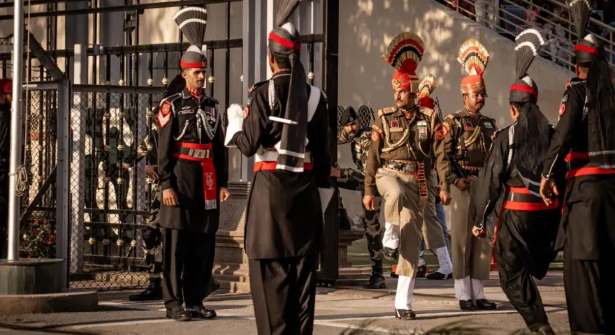 Żołnierze w barwnych mundurach, z pióropuszami na głowach, podczas ceremonii na granicy. To widok, który może przypominać o tym, co można przywieźć z Indii – wspomnienia i dumę.