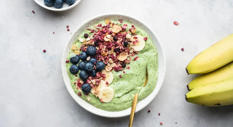 Grön smoothiebowl med blåbär, banan och granola. Ett perfekt proteinrikt mellanmål för en energifylld dag.